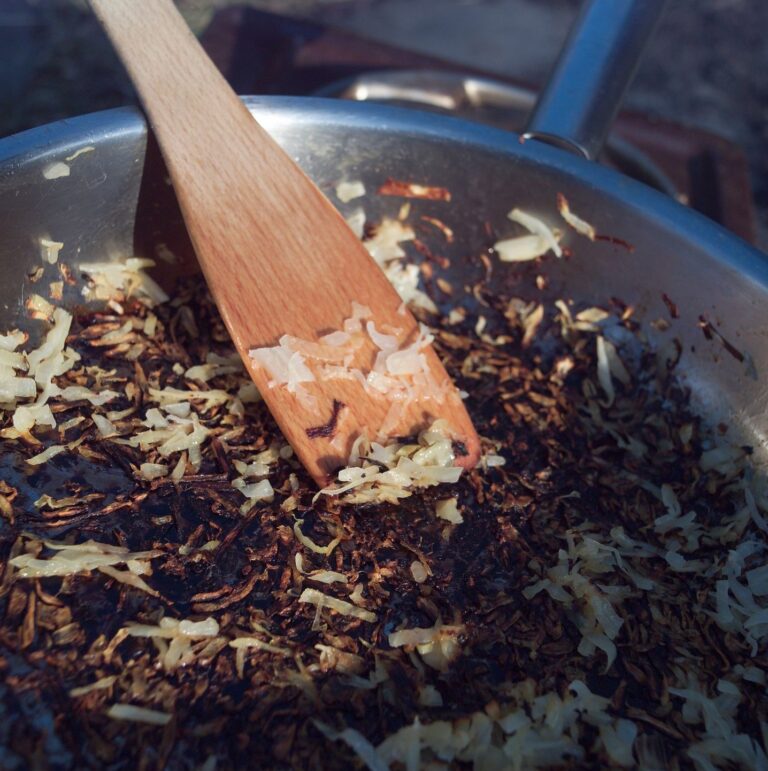 Pan with burnt hashbrowns and a spoon with the burnt hashbrowns on it.